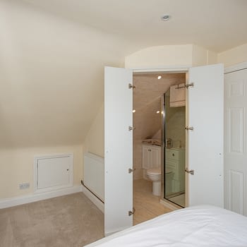 Fitted wardrobes to angled ceilings and matching doors to en-suite, colour white gloss, style Capri